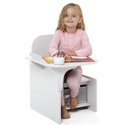 Child sitting at a small white desk with a white background