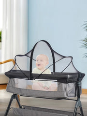 Portable baby crib with mesh side in a room with light blue walls and white curtains.
