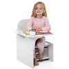 Child sitting at a small white desk with a white background