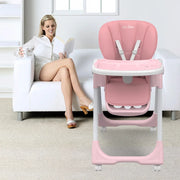 Pink baby high chair next to a woman sitting on a couch in a living room.
