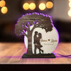 Decorative lamp with a tree design and 'James Linda forever' text on a wooden surface.