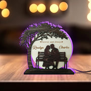 Decorative lamp with a silhouette of a couple on a bench and the text 'Forever and Always Roselyn Charles' under a tree.